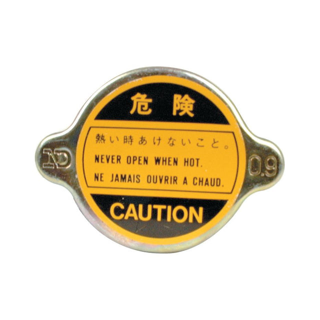 The Sparex Radiator Cap (S.63104) features a round metal caution label in yellow and black with warnings in Japanese, English, and French advising against opening when hot. The label includes a small handle on each side to ensure visibility and safety.