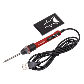 The USB Soldering Iron 8W - SDL12 by Sealey, with a red body and black handle, is perfect for hobbyists soldering or welding circuit boards. It features a long power cord ending in a USB plug and includes a black stand, making it ideal for enthusiasts using Premier Hand Tools.