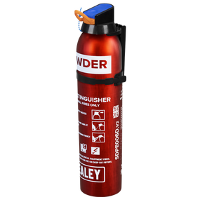 A compact 0.6kg red powder fire extinguisher, model SDPE006D by Sealey, featuring a blue safety pin and various labels, including usage instructions for B and C class fires.