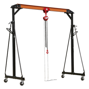 Introducing the Sealey Portable Lifting Gantry Crane Adjustable 1 Tonne & Hoist Combo - SG1000KIT, a height-adjustable gantry crane with a hoist assembly. This versatile equipment features a black and orange frame mounted on caster wheels for effortless mobility and includes chains that hang from the chain block to lift heavy objects up to 1000kg.