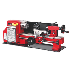 The Sealey Metalworking Lathe 300mm Between Centres - SM3002 features a red and black design, equipped with a powerful 300W motor, various adjustment knobs, a chuck for holding workpieces, and a motor housing labeled with the Sealey brand.