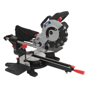 The Sealey Sliding Compound Mitre Saw Ø216mm - SMS216 features a circular TCT blade, sliding rails, and red and black adjustment controls. It includes a dust collection bag, a measurement guide on the base, and a laser guide for precise cuts.