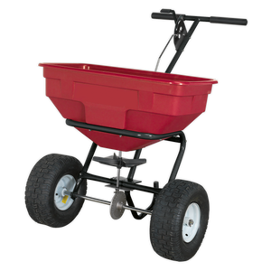 The Sealey Broadcast Spreader 57kg Walk Behind - SPB57W features a red and black design, metal frame, heavy-duty pneumatic tires, an adjustable feed system, and two handles.