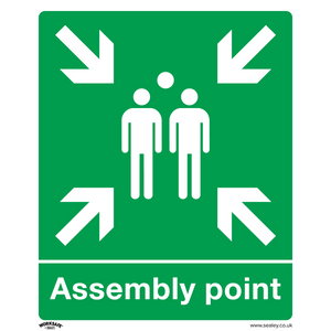 Sealey's Safe Conditions Safety Sign - Assembly Point (SS37P1) is made of rigid plastic and features white arrows pointing inward at three standing figures in the center, designating a gathering area. This green sign is ideal for commercial environments such as offices.