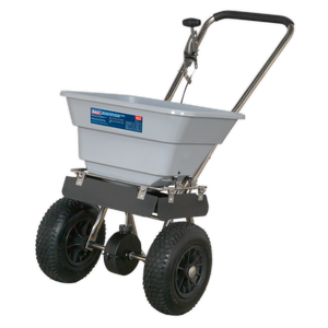 The Sealey Stainless Steel Broadcast Salt Spreader 37kg Walk Behind - SSB37W features a corrosion-resistant design with a gray hopper and black handle, ideal for distributing lawn treatments evenly over large areas. Equipped with pneumatic tires, this tool ensures easy maneuverability.