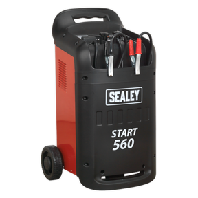The Sealey START560 Starter/Charger 560/95A 12/24V 230V, a heavy-duty red and black battery starter/charger, perfect for professional garages with its wheels and handle, features attached jumper cables ideal for battery recovery.