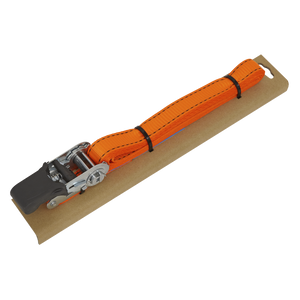 The Sealey Ratchet Tie Down 25mm x 5m Polyester Webbing with Corner Protector, featuring a durable polyester webbing and boasting a 600kg breaking strength, is secured on a rectangular piece of cardboard with a metal ratchet mechanism at one end.