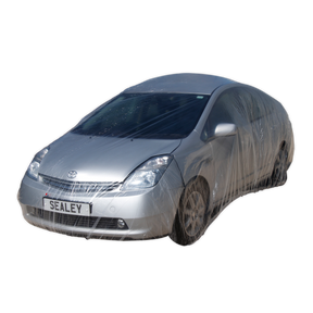 A silver car is wrapped in the Sealey Temporary Universal Car Cover Medium - TDCCM, showcasing effective vehicle protection, with a license plate that reads "SEALEY.