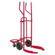 The Sealey Tyre Trolley - 150kg Capacity - TH003 is a red hand truck with tall vertical handles, curved supports, and two large pneumatic tyres designed for moving cylindrical objects, featuring a sturdy tubular steel construction.