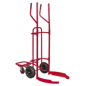 The Sealey Tyre Trolley - 150kg Capacity - TH003 is a red hand truck with tall vertical handles, curved supports, and two large pneumatic tyres designed for moving cylindrical objects, featuring a sturdy tubular steel construction.