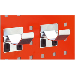 Two Sealey Pipe Brackets Ø60mm from the TTS24 pack of two are mounted on an orange PerfoWall panel, each holding a black plastic accessory behind the bracket.