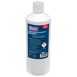 A white plastic bottle labeled "Sealey Carpet/Upholstery Detergent 1L - VMR921S" with safety warnings, showcasing the non-corrosive cleaning power of Sealey products.