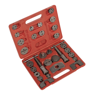 A red plastic carrying case containing the Sealey Brake Piston Wind-Back Tool Kit 30pc (VS0285) with a well-organized set of metal tools and attachments, including adapter plates for various vehicle applications.