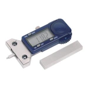 A Sealey DVSA-approved Digital Tyre Tread Depth Gauge (VS0563) with a stainless steel gauge and a separate rectangular metal block displays a calibrated measurement of 11.82 on its screen.