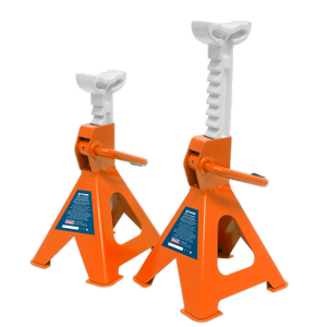 The Sealey Axle Stands (Pair) with a 2-tonne capacity per stand, model VS2002OR, are orange and white metal jack stands designed for vehicle lifting and support. They feature a ratchet-type axle stand for easy height adjustment and labeled safety instructions on their cast iron support posts.