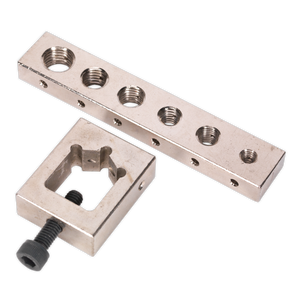 The Sealey Nut/Bolt Drill Jig - VS559 is a compact metallic block featuring multiple threaded holes and a square-shaped clamp with an attached screw, making it ideal for accurate drilling.