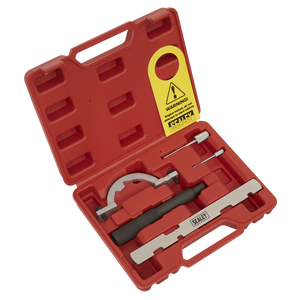 The Sealey Petrol Engine Timing Tool Kit - for GM, Suzuki 1.0/1.2/1.4 Chain Drive (VSE243) includes a red plastic carrying case filled with essential tools such as a bracket-like tool, a Sealey-labeled bar tool, a screwdriver, and a yellow warning tag. This kit is ideal for chain engines and also contains locking tools and a timing disc position gauge.