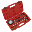 The Sealey Petrol Engine Compression Tester Deluxe Kit 6pc - VSE300D includes a red plastic case housing a 300psi pressure gauge with a flexible extension hose, three metal rods, and four brass fittings.