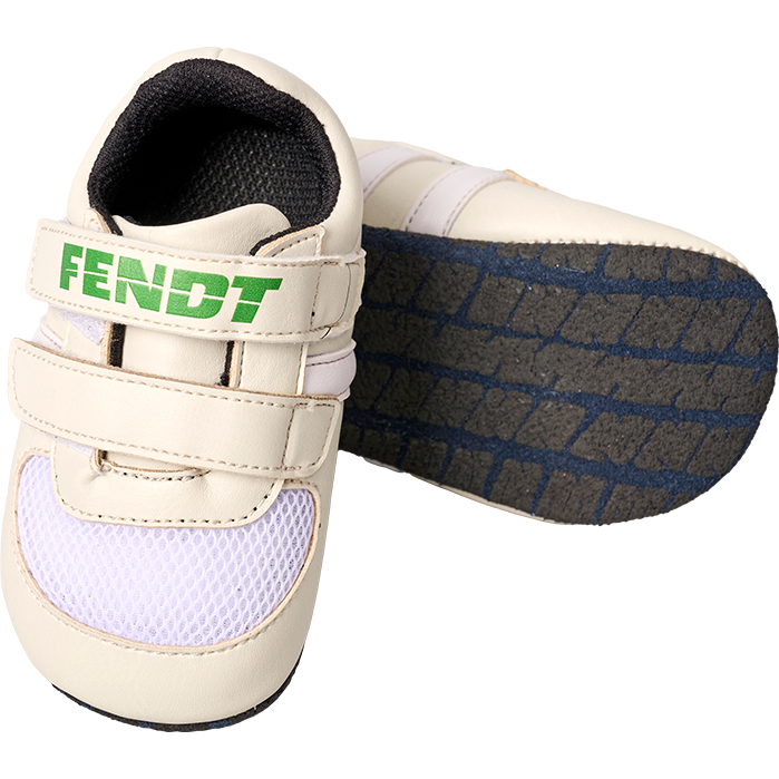 Infant-sized cream and white baby shoes with Velcro fasteners, branded "FENDT" in green on the strap, featuring black and blue rubber soles—perfect as a newborn gift. These adorable shoes are known as "Fendt - One Size Baby Shoes - X991023155000" by AGCO.