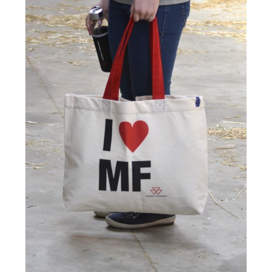 Person holding an AGCO Massey Ferguson shopping bag (Product Code: X993342304000) made of beige cotton with red handles and the text "I ♥ MF" printed on it, while carrying a black drink container.