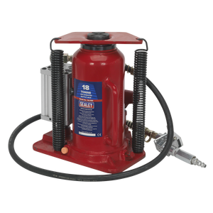 A powerful red hydraulic bottle jack, the "Sealey Air Operated Bottle Jack 18 Tonne - YAJ18S," equipped with a reliable black coil spring and connected to a grey air pump via a hose, ideal for lifting heavy vehicles.