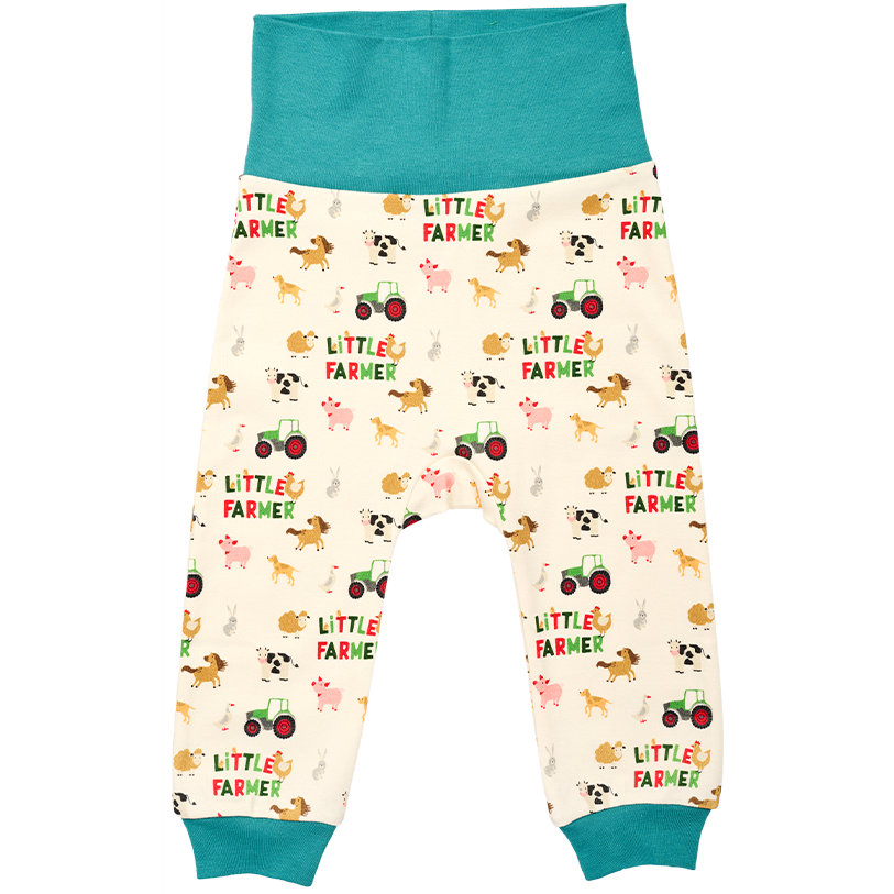 These AGCO Fendt baby pants, model X991023164000, feature a teal waistband and cuffs with a charming farm-themed pattern showcasing animals, tractors, and the words "LITTLE FARMER" on a cream background. Made from Bio-cotton Interlock, they offer a relaxed fit that is both comfortable and environmentally friendly.