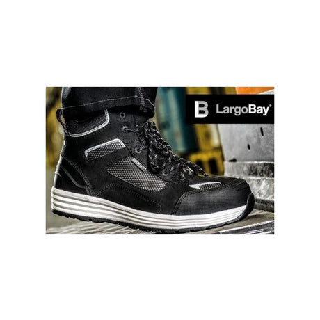 A close-up of a *SPECIAL PRICE* - Buckler - Largo Bay Safety Trainer - BAZBK with a white sole, worn by a person. The branding "JMCE" is visible in the upper right corner of the image, showcasing its composite toe cap and slip-resistant design.