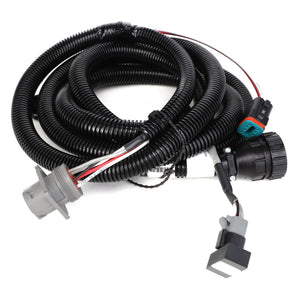 The AGCO | HARNESS - AG136332 by AGCO is a meticulously coiled black wiring harness that features various connectors and includes some exposed red, white, and black wires.