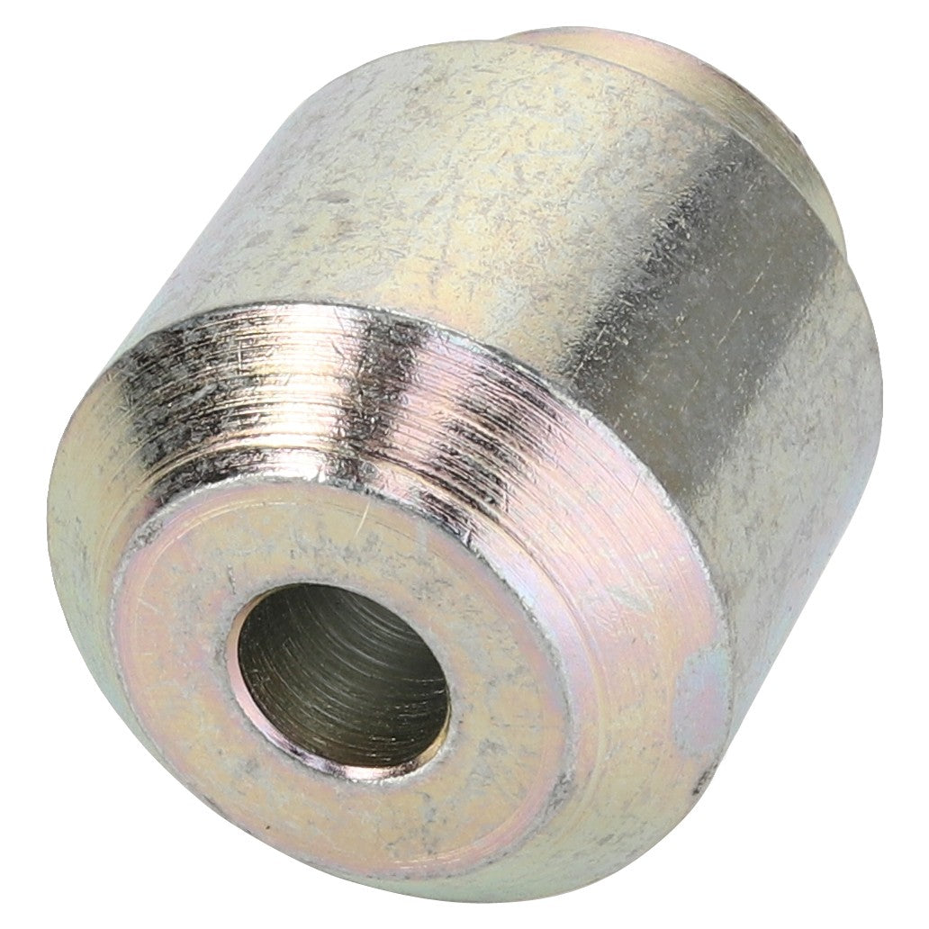 The AGCO Bush - Acw8516960 is a cylindrical metal spacer with a central hole, featuring a shiny, reflective finish.