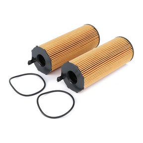 Two cylindrical AGCO Engine Oil Filter Cartridges - F653201510010, featuring pleated paper surfaces, black end caps, and high-grade circular rubber gaskets, are placed beside them on a white background, ensuring maximum protection for your engine.