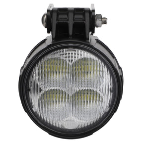 The AGCO Work Lamp - Acw400954A is a round LED work light featuring a black housing and a clear lens, mounted on a sturdy metal bracket with a bolt.