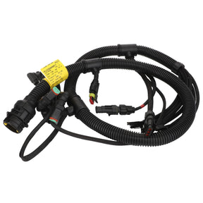 The AGCO | Harness - Acw336008B is a coiled automotive wiring harness featuring various interconnected black cables, plugs, and connectors with a yellow label attached. Please note that no current product description information is available.