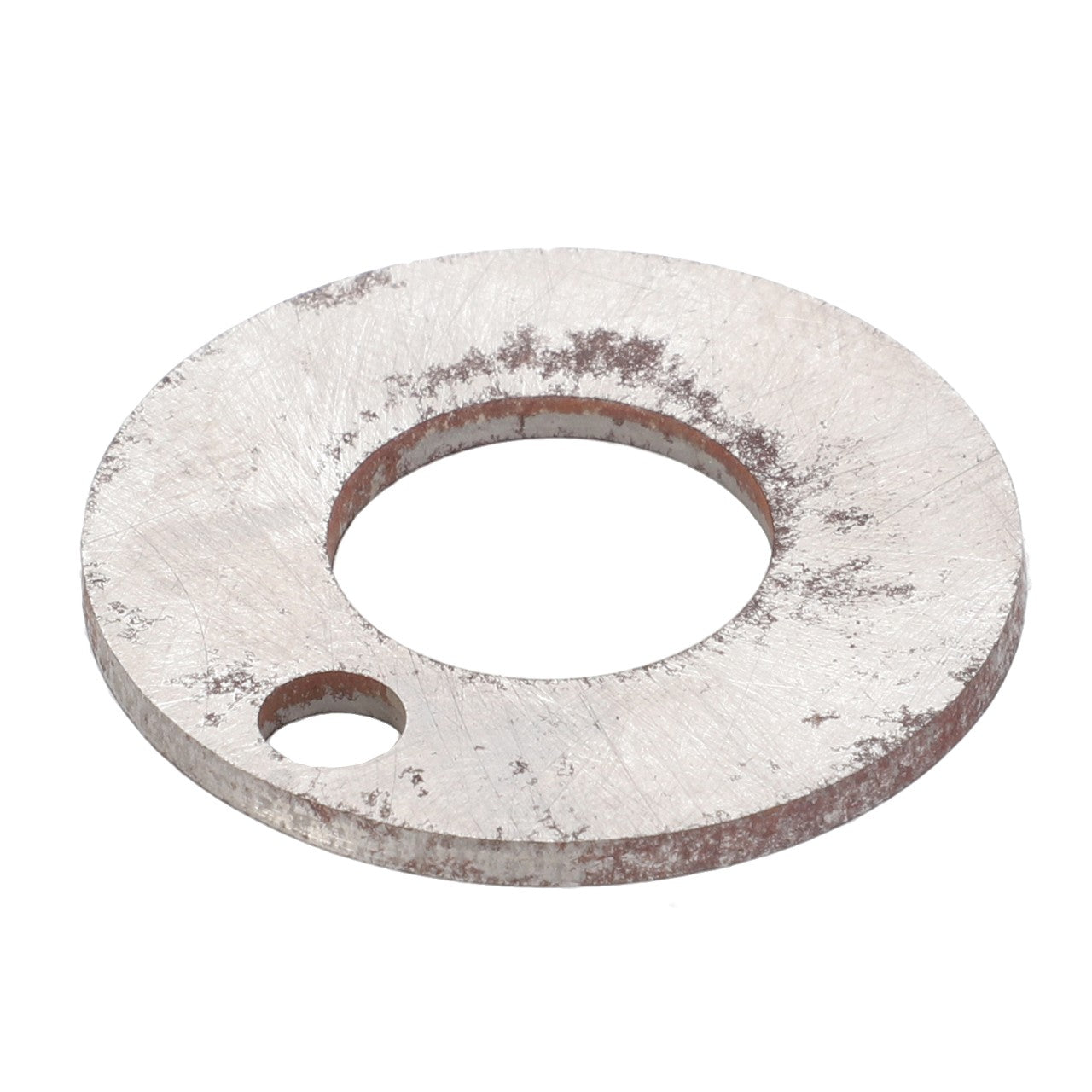 The AGCO | Shim - F181108080013 is a flat, round, metal washer featuring a larger central hole and a smaller secondary hole on one side, both displaying signs of wear and oxidation.