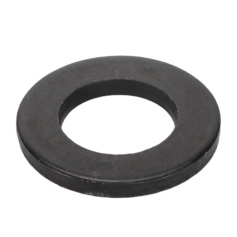 A close-up of the AGCO Flat Washer - Acw9114020, a black metal washer with a central hole, showcases this annular disc used in mechanical assemblies.