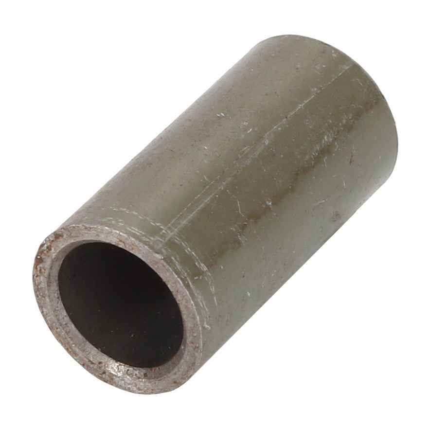 Close-up of the AGCO BUSH - D28981237 cylindrical metal pipe fitting, featuring a hollow center and a weathered exterior surface. No current product description available.