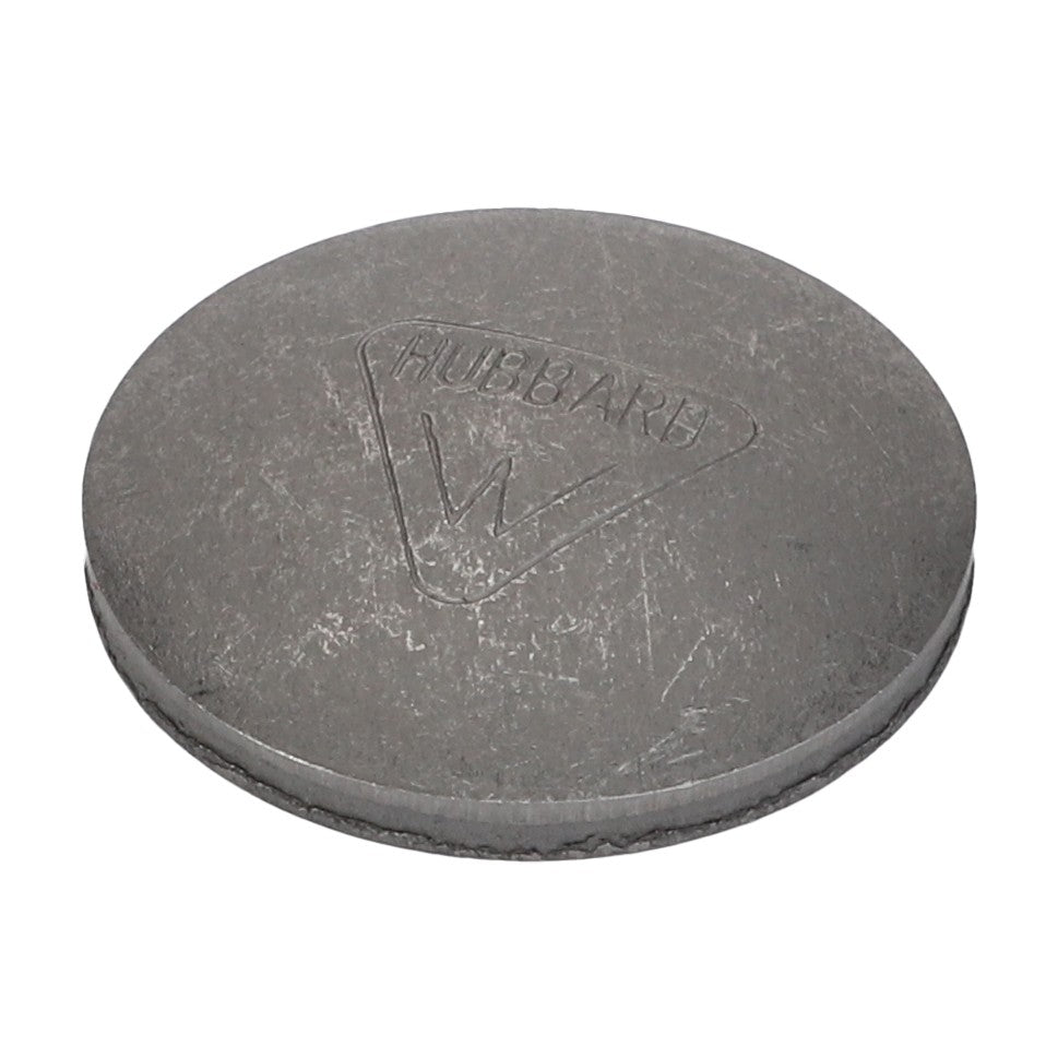 A round, flat metal object with an embossed triangular symbol and the word "Hubbare" inscribed within it, often found in Valtra models, is known as the AGCO Plug - 70910004.