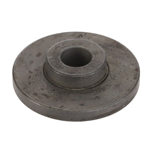 The AGCO Spacer - Acw2848560 is a circular metal disc featuring a central hole and a smaller elevated circular section around it. The surface shows signs of wear and slight discoloration, suggesting that it currently lacks an available product description.