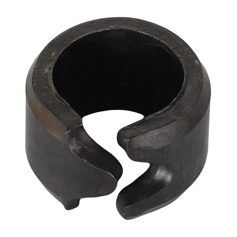 A close-up image of an AGCO Spring Tension Bushing - Acp0012100, a dark circular metal part with an open side, resembling a clamp or ring.