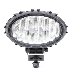 The AGCO | Work Light, LED - ACW3783570 is a round, black automotive fog light with a ribbed glass lens that ensures optimal visibility and features mounting hardware attached at the bottom.