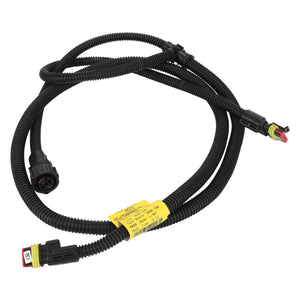 A coiled black wiring harness with connectors at both ends and a yellow label attached in the middle, known as the AGCO Harness - Acw7588940 by AGCO. No current product description information is available.