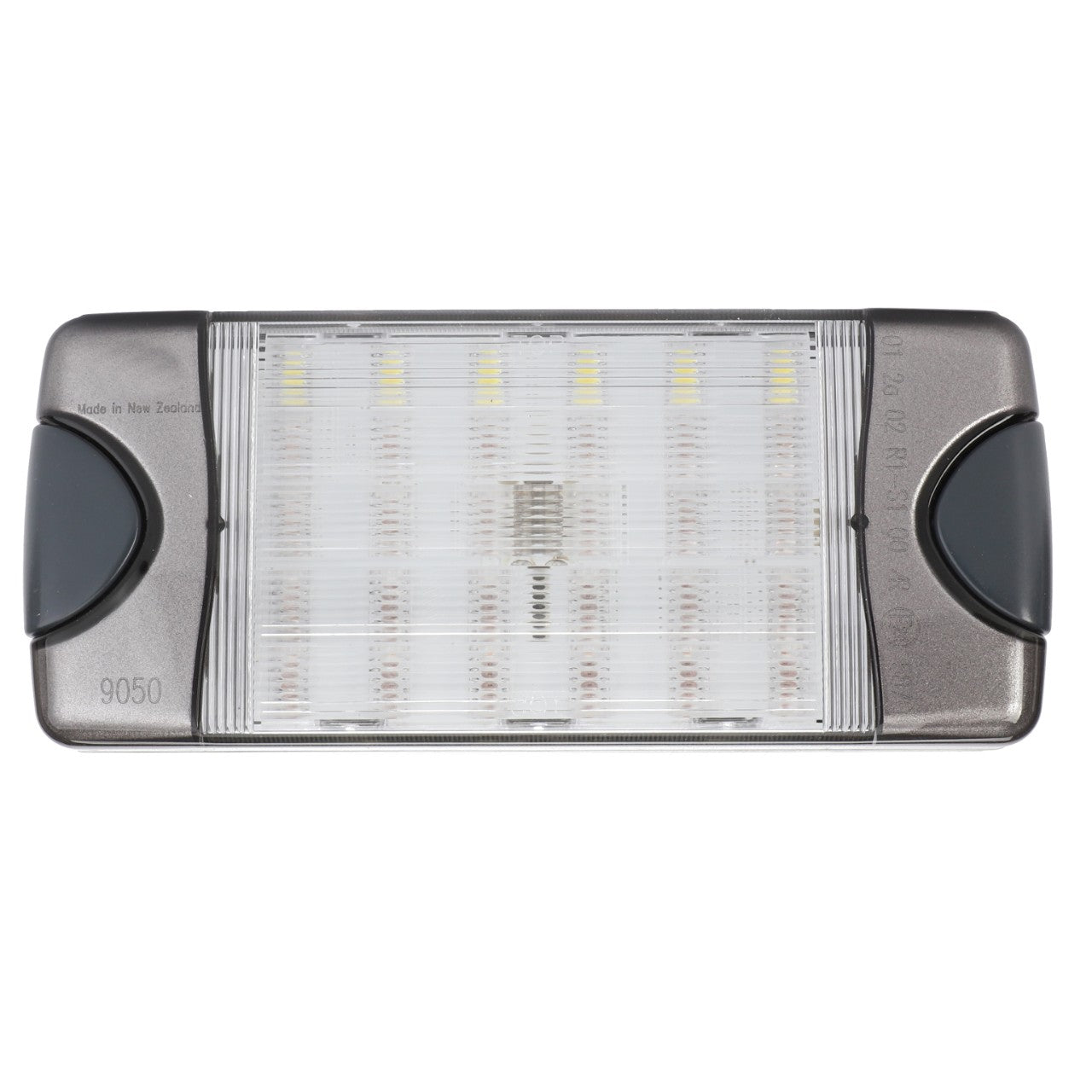 The AGCO Combination Light - 6317364M1 is a rectangular LED light fixture featuring a transparent cover, black side accents, and a ribbed design that reveals the visible LED components inside. The markings "9050" and "Made in New Zealand" are stamped on it. Ideal for tractor illumination, this product guarantees the reliability and performance synonymous with AGCO Genuine Rear Lights.