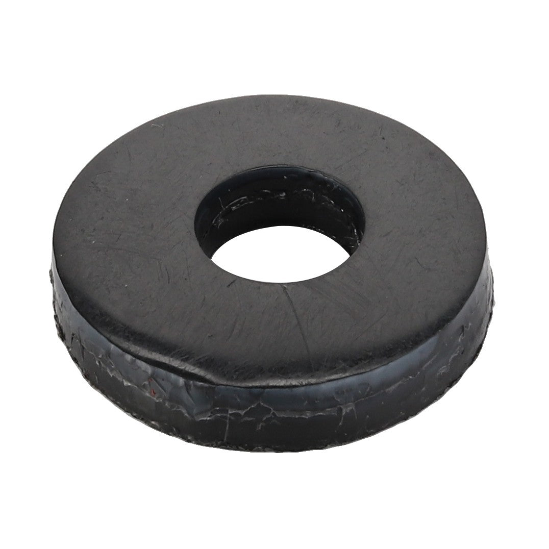 A black rubber washer with a central hole, appearing slightly worn around the edges. This item is branded as AGCO and has the product name Bush - Acx0096350. No current product description information is available.