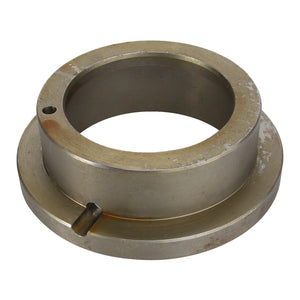 The AGCO | Bush - Acp0330690 is a circular metal mechanical component featuring a central hole, flanged edges, and two notches. It shows slight wear and tarnish on its surface.