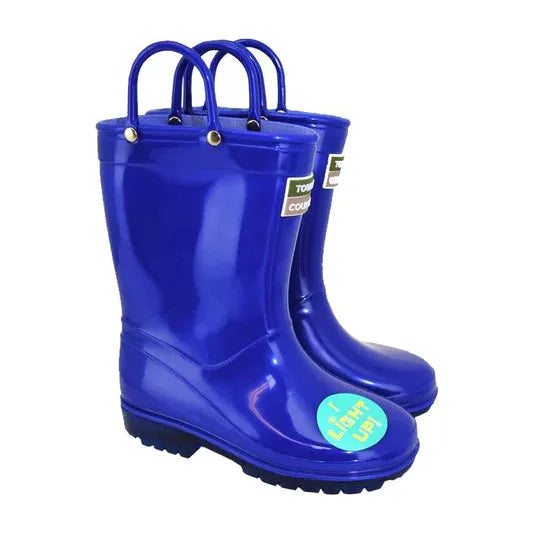 A pair of Children's Light Up Wellies - Red & Blue - TFW by JMCE, featuring durable PVC construction with a glossy finish. These red and blue rubber rain boots come with convenient handles on top and fun stickers on the sides and toe that say "It lights up!" Available in kids' sizes.