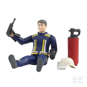 The Bruder Fireman with accessories - U60100 is a highly detailed 1:16 scale action figure dressed in a blue and yellow firefighter suit, sitting with a handheld radio. Nearby, there's a red fire extinguisher and a firefighter helmet. This collectible is part of the Unit Set series.