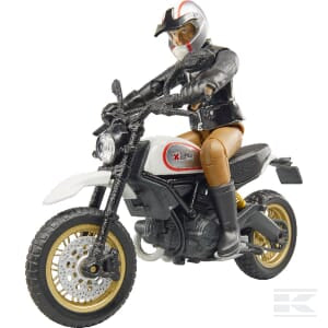 Action figure wearing a motorcycle helmet and riding the detailed Bruder Ducati Desert Sled + Driver (U63051) with a white cover and gold rims.