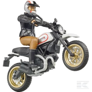 The Bruder Ducati Desert Sled + Driver (U63051) features an action figure performing a wheelie on a black and white Ducati. The driver is dressed in a black jacket, brown pants, and a helmet with a red stripe.