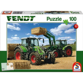 The Fendt - 100-Piece Jigsaw Puzzle - X991017198000 by AGCO features a puzzle box cover depicting two green tractors in a field, with one tractor lifting a hay bale. Suitable for ages 6 and up, this puzzle includes the iconic Fendt 724 Vario.