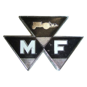 The AGCO Massey Ferguson - 100 Series Front Bonnet Badge (194234M1) is a black and silver emblem featuring three connected triangles that display the letters "M" and "F," along with an image of a tractor at the top center.
