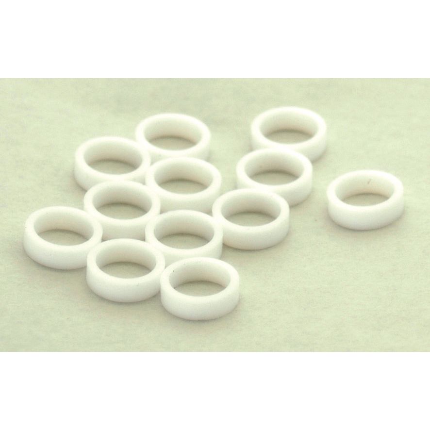 Twelve PTFE Injector Washers from Sparex (Agripak 12 pcs., Part No.S.11458) are arranged loosely on a light surface.